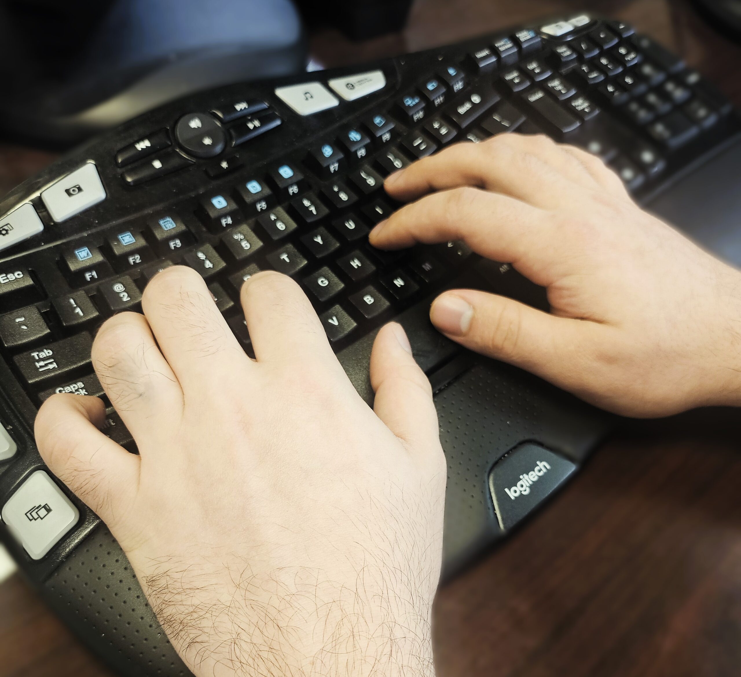 Hands typing on keyboard, using AI effectively without taking away the human element